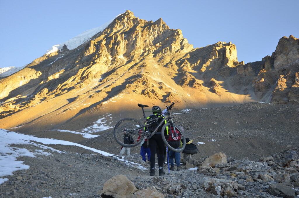 Carrying bike up Thorong La